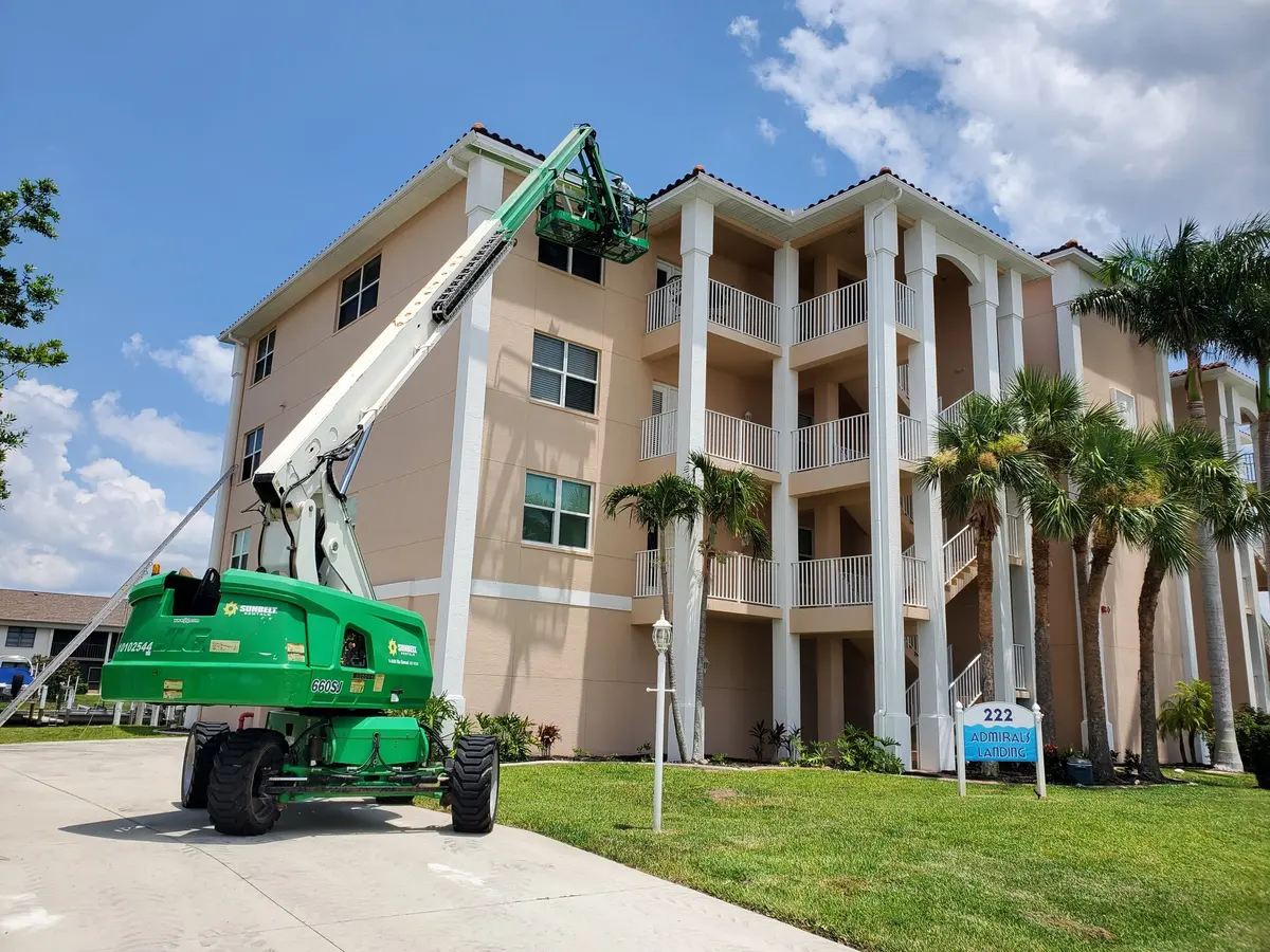 Boom lift reaching the roof of a four-story condo building